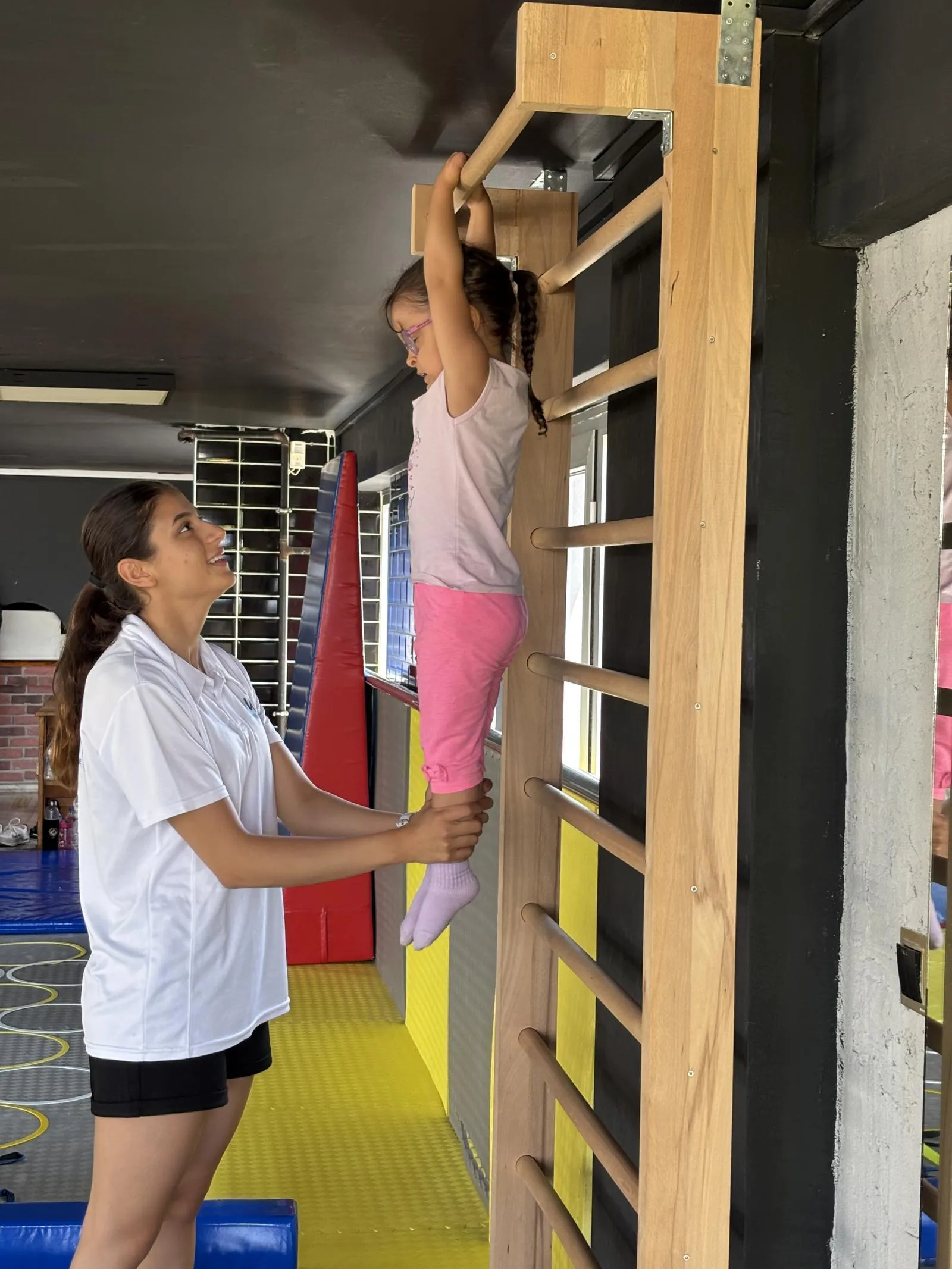 Akdeniz Üniversitesi mezunu eğitmen eşliğinde cimnastik yapan çocuk