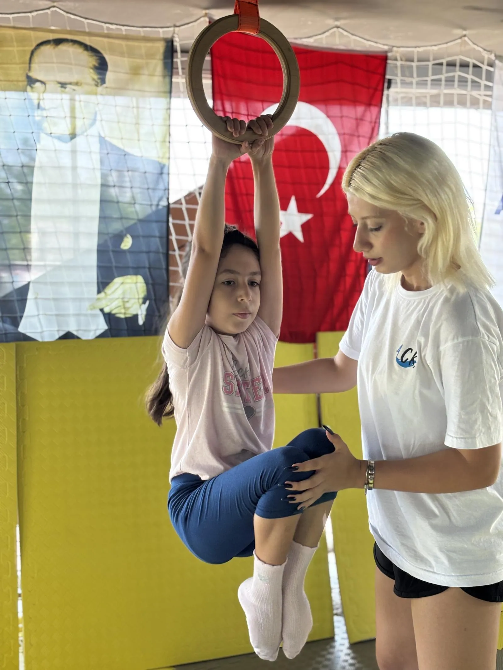 Antalya cimnastik kursunda eğitmen eşliğinde çalışan çocuk