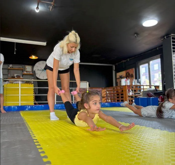 Antalya cimnastik kursunda esneme hareketi yapan mutlu bir çocuk